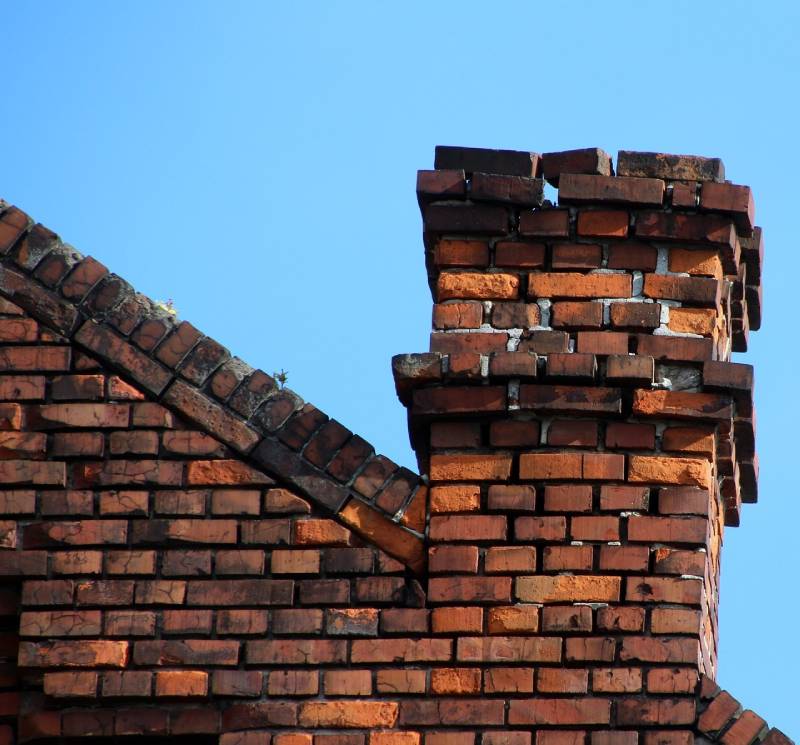Damaged chimney on an Westchester home showing cracks and missing mortar